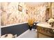 Decorated powder room featuring patterned wallpaper, elegant vanity with marble countertop, and decorative tile flooring at 5293 Sandy Shoals Ln, Stone Mountain, GA 30087