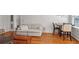 Open living area with hardwood floors, a comfortable sofa, and a dining area by the windows at 690 Piedmont Ne Ave # 17, Atlanta, GA 30308