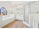 Bright bathroom featuring stained glass window, soaking tub and glass enclosed shower at 765 Brooks Cir, Stone Mountain, GA 30087