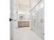 This bathroom features a glass shower, marble tile, double doors, and double vanity with good lighting at 114 Village Green Ave, Woodstock, GA 30189