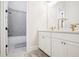 Bright bathroom featuring a double sink vanity, modern fixtures, and a bathtub with shower at 114 Village Green Ave, Woodstock, GA 30189
