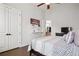 This bedroom features a bed, ceiling fan, and a doorway to the upstairs hallway, with decor at 114 Village Green Ave, Woodstock, GA 30189