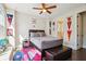 This bedroom features decor, a bed, a ceiling fan, and a doorway to a bathroom at 114 Village Green Ave, Woodstock, GA 30189