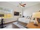 Cozy bedroom with dark hardwood floors, a ceiling fan, and ample natural light at 114 Village Green Ave, Woodstock, GA 30189
