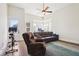 This bonus room features a couch, oversized chair, ceiling fan, and a door to a balcony at 114 Village Green Ave, Woodstock, GA 30189