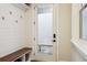 Well-lit mudroom with coat hooks, bench, storage, and view of the outdoors at 114 Village Green Ave, Woodstock, GA 30189