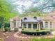 An elegant brick home displays a covered patio and manicured landscaping in the backyard at 3905 Merriweather Woods, Johns Creek, GA 30022