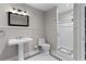 Well-lit bathroom features a pedestal sink, black-and-white tiled floor, and glass-enclosed shower at 3905 Merriweather Woods, Johns Creek, GA 30022