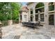 Spacious outdoor stone patio features an outdoor dining set with a beautiful brick-house view at 3905 Merriweather Woods, Johns Creek, GA 30022
