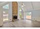 Bright living room boasts a stone fireplace, tall windows, vaulted ceilings, and light hardwood floors at 125 Sandridge Ct, Alpharetta, GA 30022