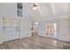 Spacious living room with gray floors, built-in shelving, crown molding, and french doors at 125 Sandridge Ct, Alpharetta, GA 30022