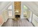 Bright living room with vaulted ceilings, gray floors, stone fireplace, and a ceiling fan at 125 Sandridge Ct, Alpharetta, GA 30022