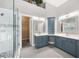 Well-lit bathroom featuring blue vanities, walk-in shower, and an open closet at 150 Rose Creek Dr, Covington, GA 30014