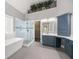 A spacious bathroom with dual sink vanity, walk-in shower, soaking tub and plant decor at 150 Rose Creek Dr, Covington, GA 30014