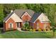 Brick house with manicured lawn, black mulch, and green shrubbery at 150 Rose Creek Dr, Covington, GA 30014