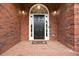 Brick home featuring a black front door with an arched window, flanked by sidelights and sconce lighting at 150 Rose Creek Dr, Covington, GA 30014