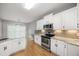 Charming kitchen with white cabinets, granite countertops, stainless appliances, and an eat-in breakfast area at 150 Rose Creek Dr, Covington, GA 30014