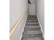 Carpeted staircase with wooden handrail leads to the upper level of the home at 150 Rose Creek Dr, Covington, GA 30014