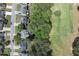 Aerial view of the neighborhood showcasing homes, a road, tree coverage, and a spacious green lawn area at 320 Ironhill Trce, Woodstock, GA 30189