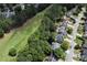 Aerial view showcasing homes with manicured lawns and mature trees bordering a lush golf course at 320 Ironhill Trce, Woodstock, GA 30189
