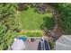 Backyard view with a lush lawn, stone-lined fire pit, a wood deck with outdoor seating, and mature trees at 320 Ironhill Trce, Woodstock, GA 30189