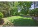 Expansive backyard with lush lawn and fire pit seating area at 320 Ironhill Trce, Woodstock, GA 30189