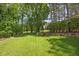 An expansive backyard with a meticulously maintained lawn and stone fire pit, framed by mature trees and greenery at 320 Ironhill Trce, Woodstock, GA 30189