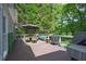 Outdoor deck with dining table, seating, grill, and a view of the backyard at 320 Ironhill Trce, Woodstock, GA 30189