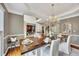 Open-concept dining area with a wooden table, seating for six, and seamless transition to the adjacent living spaces at 320 Ironhill Trce, Woodstock, GA 30189