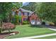 Charming two-story brick home featuring a well-manicured lawn, two-car garage, and classic architectural details at 320 Ironhill Trce, Woodstock, GA 30189