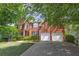 Beautiful brick home boasting a manicured lawn, black shutters, and a two-car garage, set against a backdrop of trees at 320 Ironhill Trce, Woodstock, GA 30189