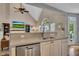 Bright kitchen featuring stone counters, stainless dishwasher, and a view of the living room with vaulted ceiling at 320 Ironhill Trce, Woodstock, GA 30189