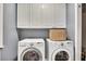 Functional laundry room with front load washer and dryer, storage cabinets, and gray walls at 320 Ironhill Trce, Woodstock, GA 30189