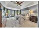 Cozy primary bedroom boasting a plush king bed, bay windows, and a tray ceiling at 320 Ironhill Trce, Woodstock, GA 30189