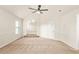 A large room with beige carpet, featuring high ceiling and archway at 321 Shannon Ct, Mcdonough, GA 30252