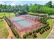 Community tennis courts surrounded by lush landscaping, hedges, and trees at 321 Shannon Ct, Mcdonough, GA 30252