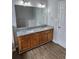 Bathroom features a double sink vanity with wood cabinets, granite countertop, and wood flooring at 4677 Liberty Square Dr, Acworth, GA 30101