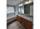 Bathroom features a double sink vanity with wood cabinets, granite countertop, and wood flooring at 4677 Liberty Square Dr, Acworth, GA 30101