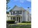 Two-story home featuring gray siding, black shutters, a chimney, and a well-manicured lawn with green shrubs at 4677 Liberty Square Dr, Acworth, GA 30101