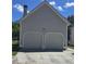 Two-car garage with light gray doors providing convenient parking and additional storage space at 4677 Liberty Square Dr, Acworth, GA 30101