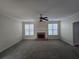 Living room with a brick fireplace, ceiling fan, and large windows for natural light at 4677 Liberty Square Dr, Acworth, GA 30101