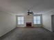 Bright living room with a brick fireplace, ceiling fan, and large windows at 4677 Liberty Square Dr, Acworth, GA 30101