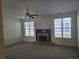 Spacious living room with gray carpet, brick fireplace, two large windows, and modern ceiling fan at 4677 Liberty Square Dr, Acworth, GA 30101