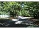 Road lined with green trees and a white fence on the side, creating a picturesque and inviting street view at 4677 Liberty Square Dr, Acworth, GA 30101