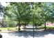 Scenic street view with mature trees, street lamp, and sidewalks in a quiet residential neighborhood at 4677 Liberty Square Dr, Acworth, GA 30101