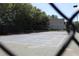 View of a community tennis court through a fence, showcasing its well-maintained surface at 4677 Liberty Square Dr, Acworth, GA 30101