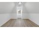 Attic bedroom featuring wood-look floors, white walls, and a window at 816 Ivy Ridge Dr, Loganville, GA 30052
