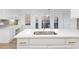 Modern kitchen island with marble countertops and a sink, complemented by ample lighting at 816 Ivy Ridge Dr, Loganville, GA 30052