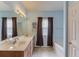 Well-lit bathroom featuring a double sink vanity and separate tub at 965 Under Ct, Sugar Hill, GA 30518