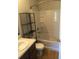 Bright bathroom with a shower-tub combo, laminate flooring, and a shelving unit at 1843 Grove Way, Hampton, GA 30228